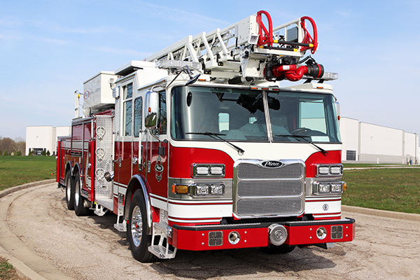 A red and white 100' Heavy-Duty Low Profile Steel Aerial Ladder truck parked on a slight angle.