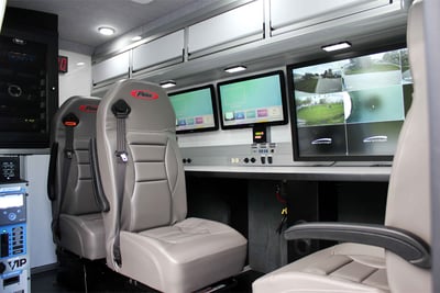 A CRU-22 vehicle is ready for any situation as this image displays the swivel chairs along the computer monitor workstation with access to the internet, a rooftop camera, printer, and more. 