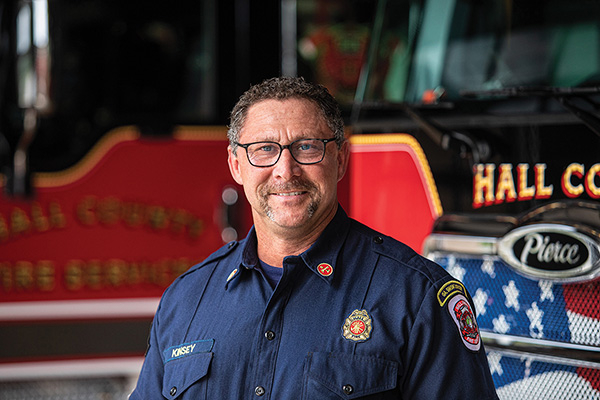 Hall County Fire Department Chief standing in front of Pierce fire aerial ladder fire truck