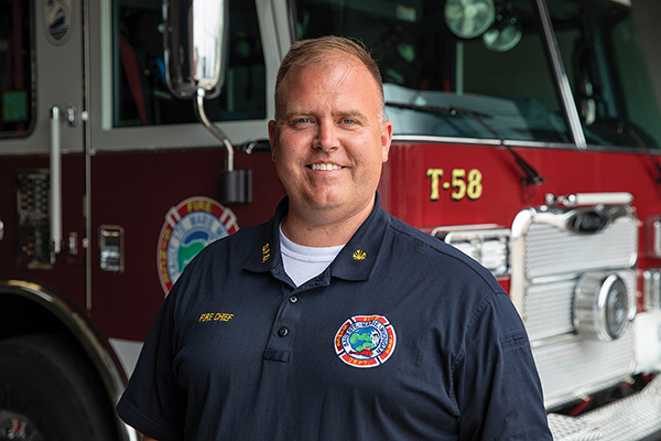 Chief of Sale Ste. Marie Fire Department in Front of New 100' MidMount Platform Fire Truc