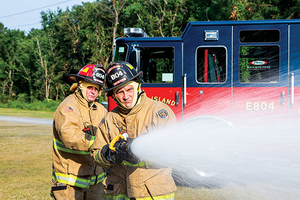 Firefighters spraying water from custom pumper fire truck