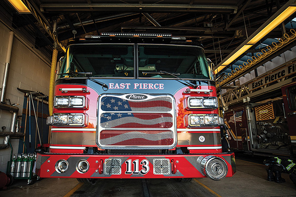 Tiller aerial fire truck parked in fire station