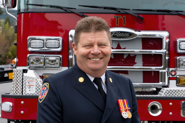 West Vancouver Fire Chief smiling in front of their 100 MidMount Aerial Platform