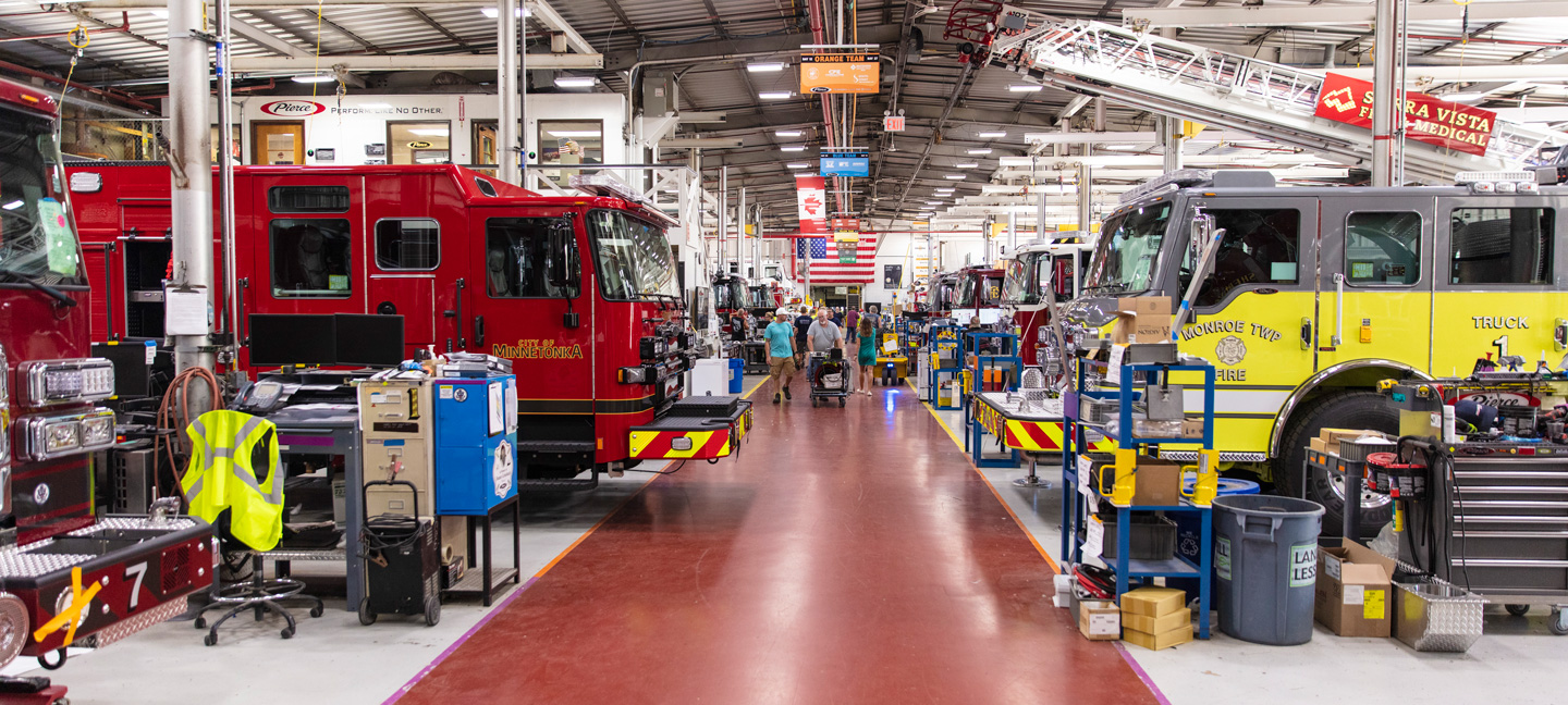 Pierce Fire Truck Manufacturing Facility with people walking in the middle of the walk way.