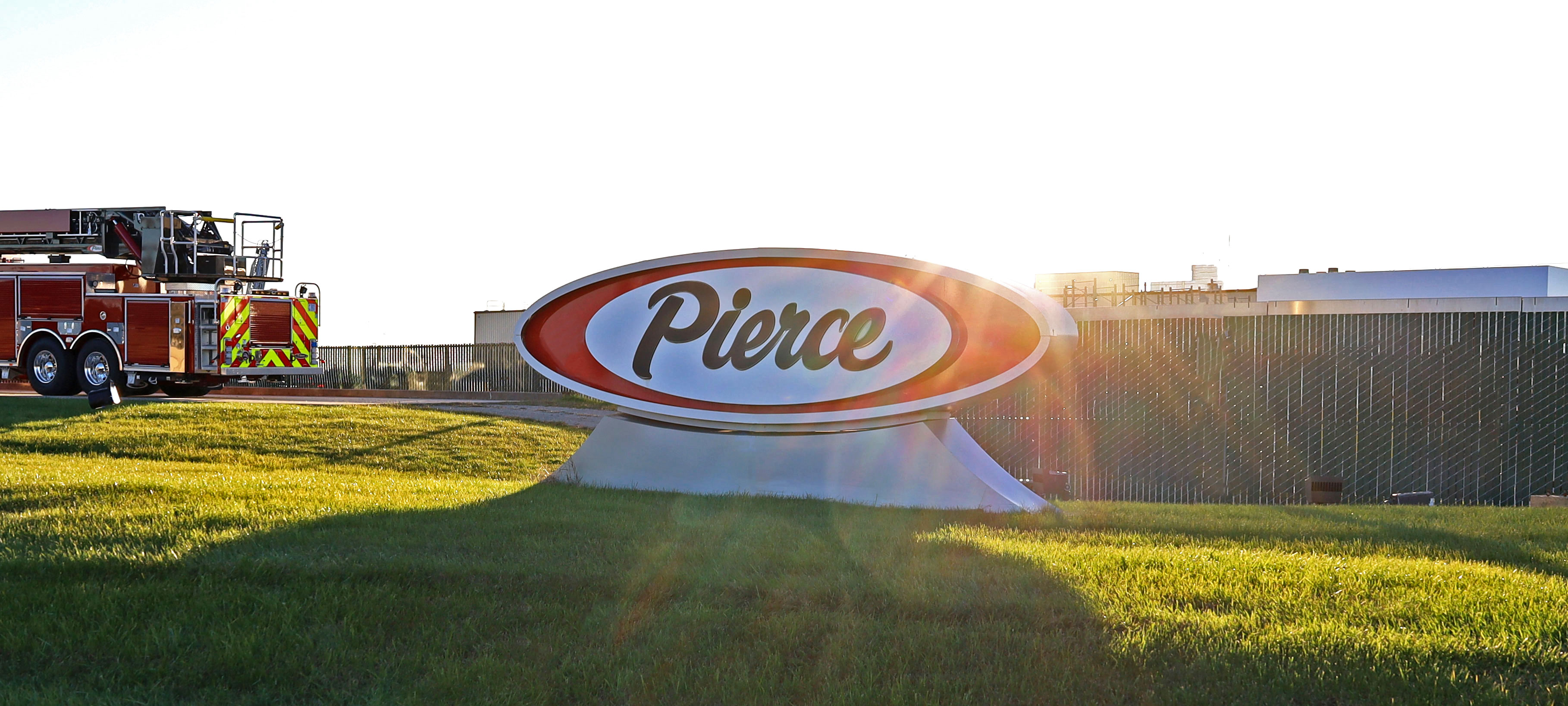 Pierce Manufacturing sign with sun setting in background