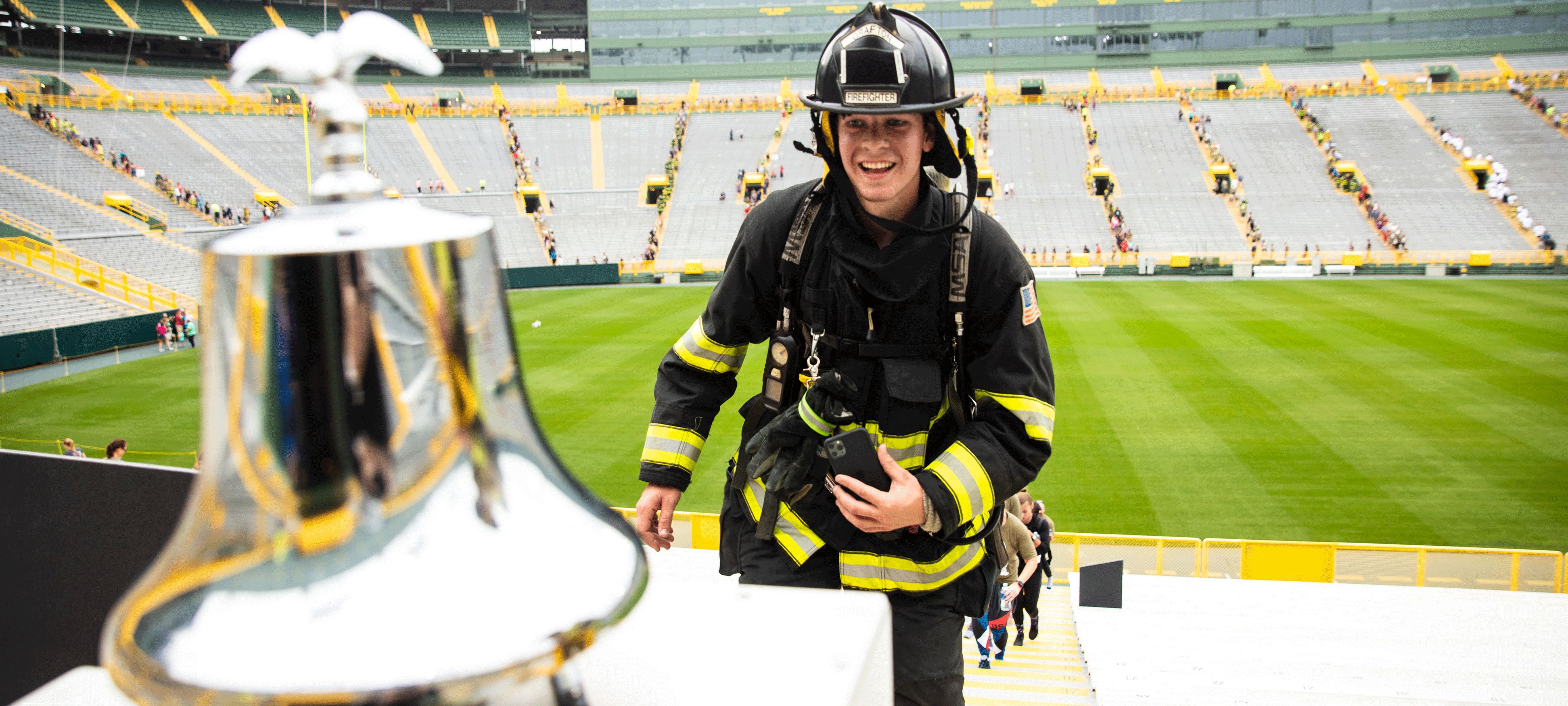 9/11 Memorial Stair Climb firefighter approaching bell to ring in Lambeau Field